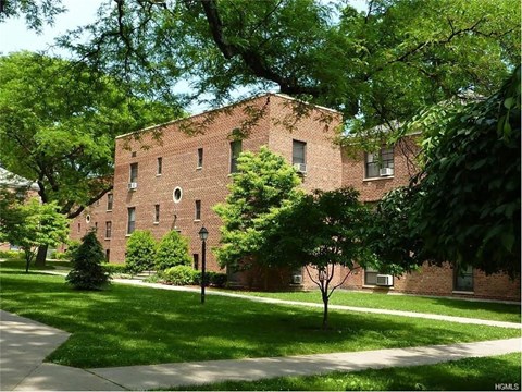 A tree in front of a red brick building.