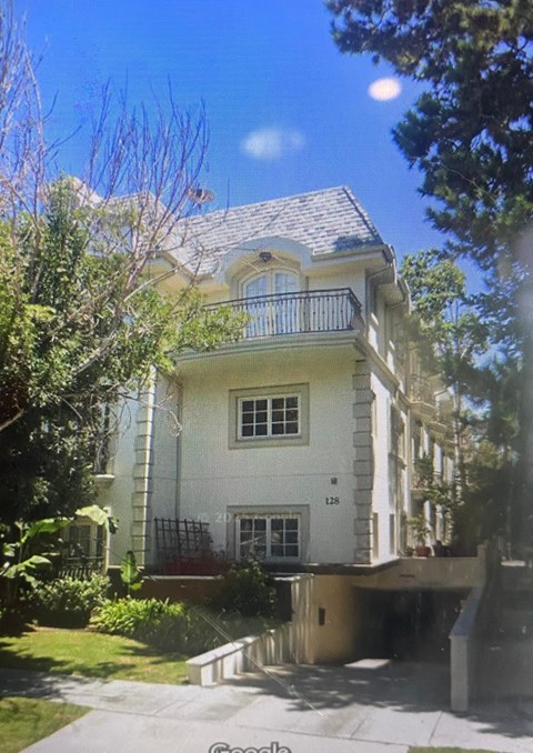 A white house with a balcony on the second floor.