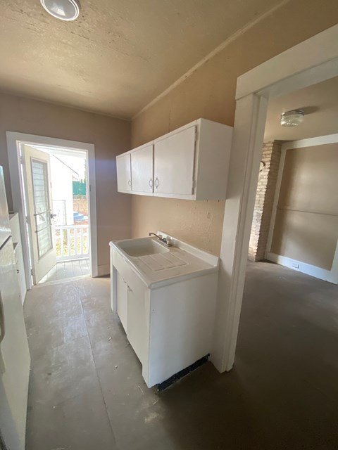 A kitchen with white cabinets and a sink.