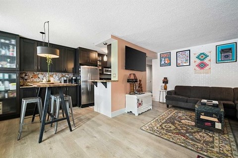 A kitchen with a refrigerator, a table, and a couch.