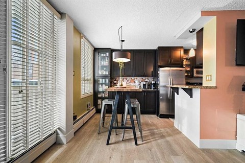 A kitchen with a table and chairs in the middle of the room.