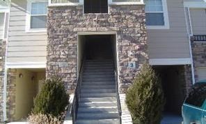 A stone building with a staircase leading to a door.