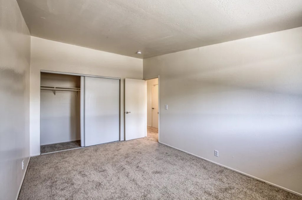 A room with a grey carpet and white walls.