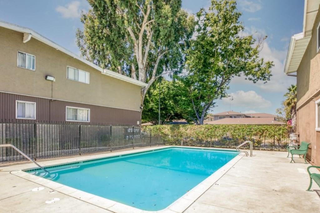A small pool in a backyard surrounded by a fence.