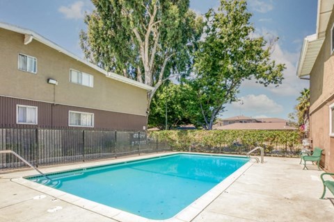 A small pool in a backyard surrounded by a fence.