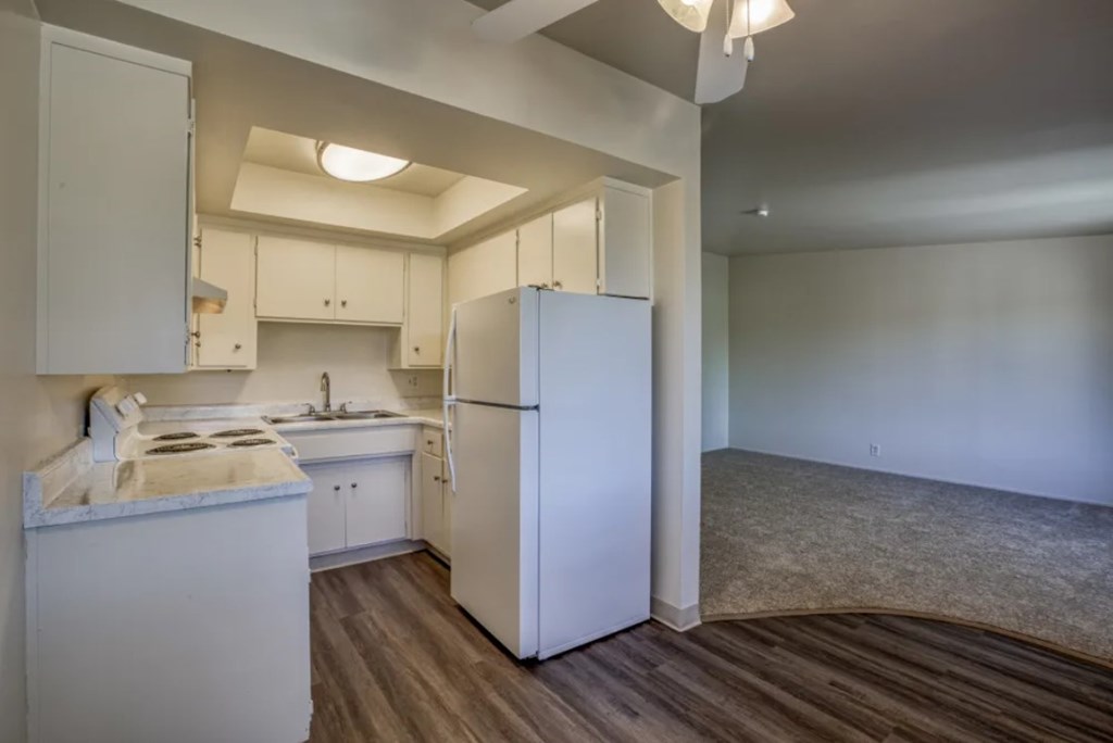 A kitchen with white appliances and cabinets.