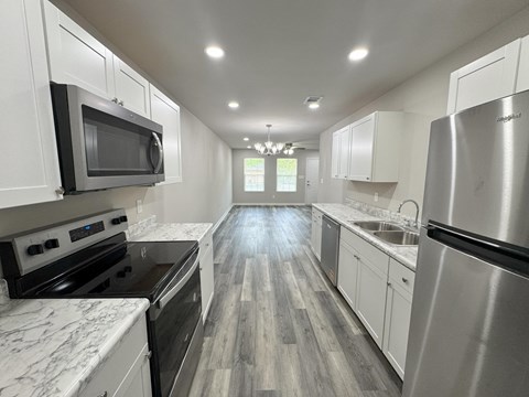 A modern kitchen with stainless steel appliances and white cabinets.
