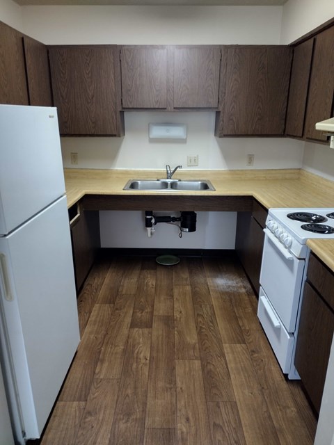 A kitchen with a white refrigerator and a white stove.