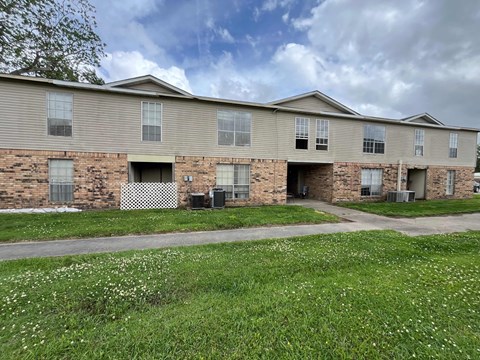 Apartment building with a grassy area in front.