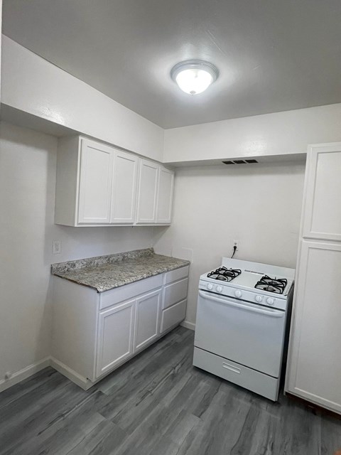 A kitchen with a stove and cabinets.