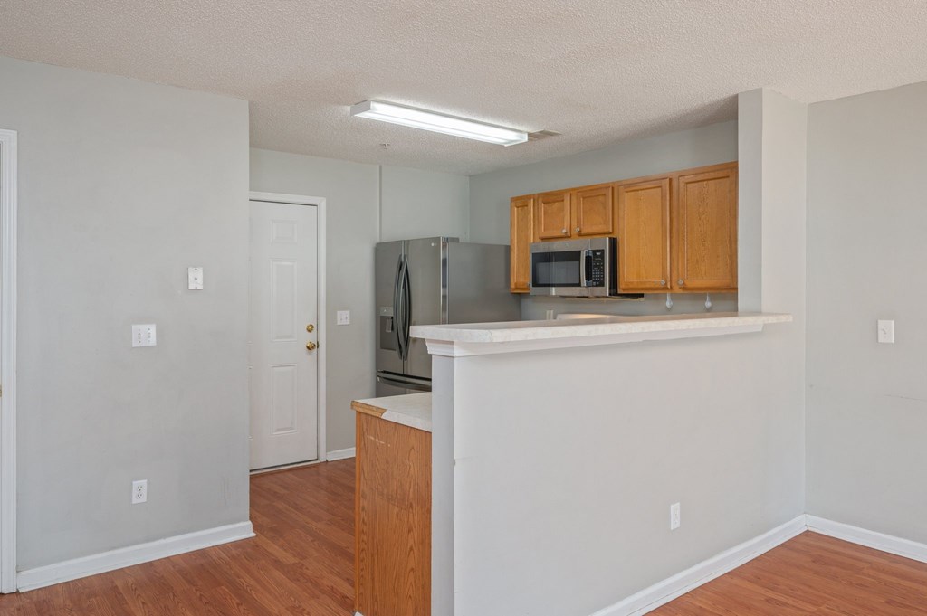 A kitchen with wooden cabinets and a microwave.