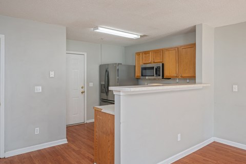 A kitchen with wooden cabinets and a microwave.