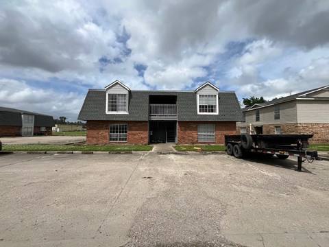 A black truck is parked in front of a brick house.