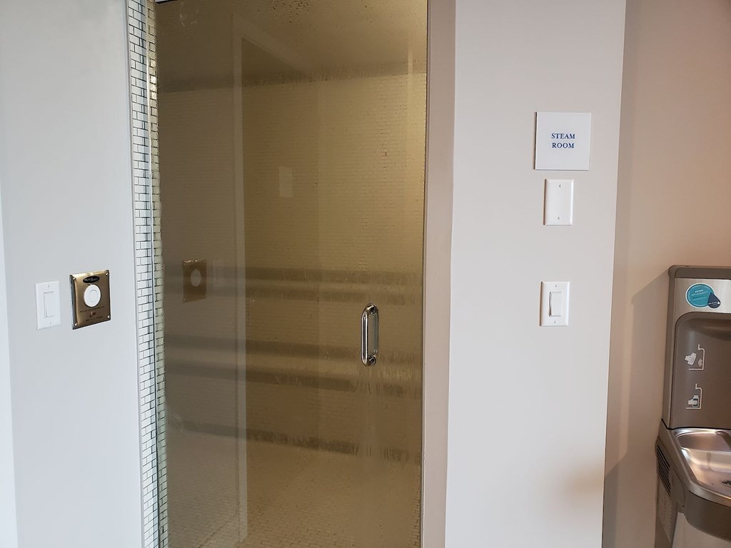 A glass door with a sign that says steam room.