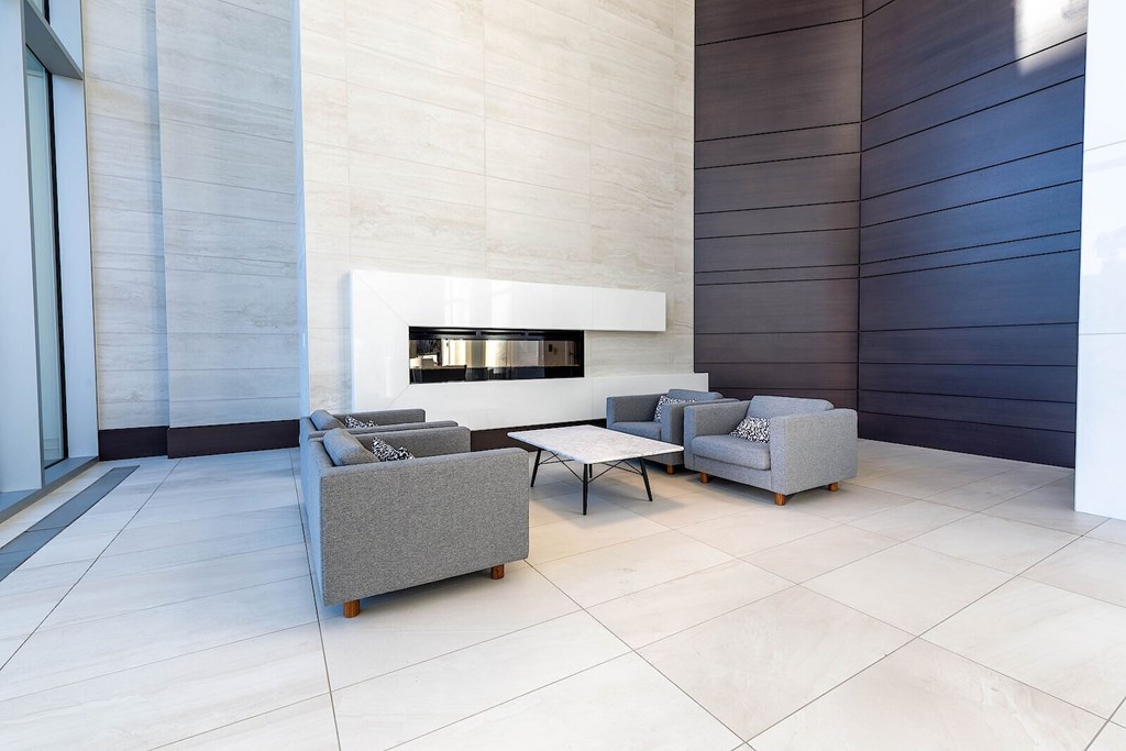 A modern living room with a grey sofa and a fireplace.