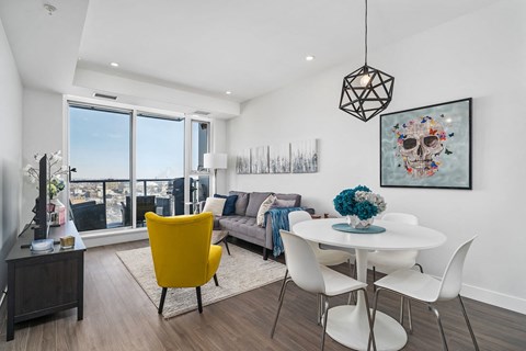 A modern living room with a yellow chair and a white table.
