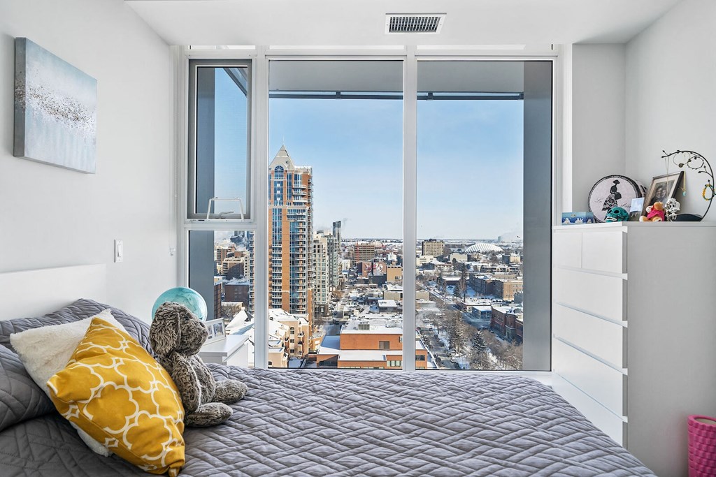 A bedroom with a large bed and a view of the city.