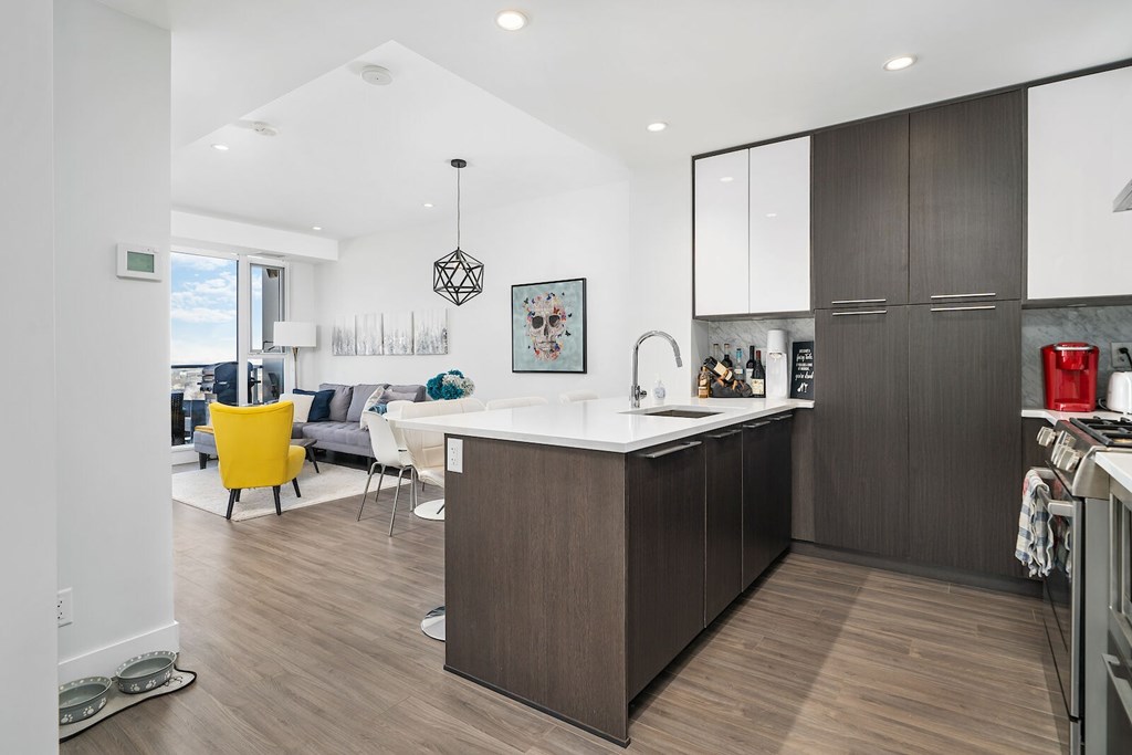 A modern kitchen with a white countertop and brown cabinets.
