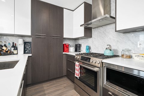 A modern kitchen with dark wood cabinets and stainless steel appliances.