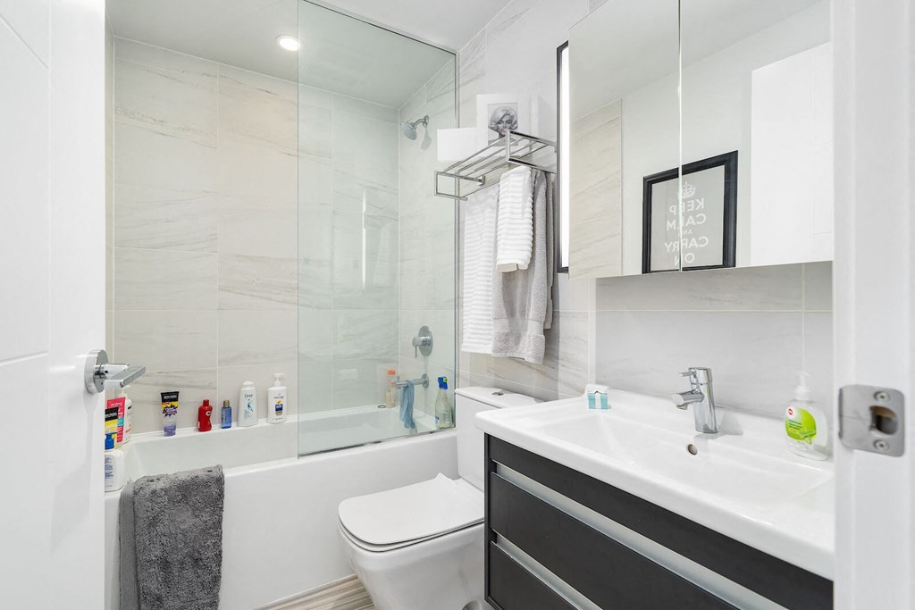 A white toilet sits next to a white sink in a modern bathroom.