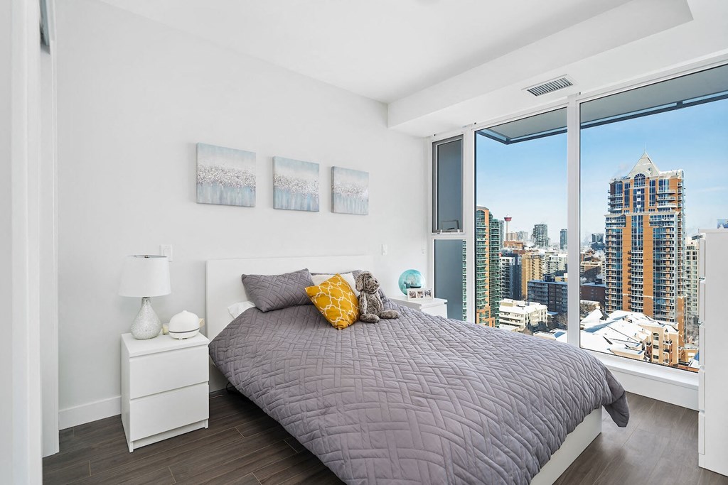 A bedroom with a large bed and a view of the city.