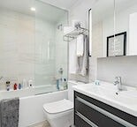 A white toilet sits next to a bathtub in a bathroom.