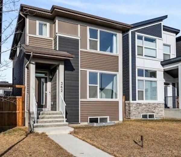 A modern two-story house with a front porch and a stone pillar.