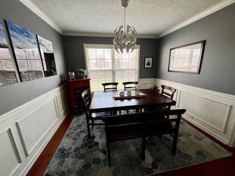 A dining room with a table and chairs.