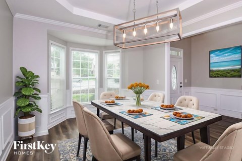 A dining room with a table set for six and a view of the ocean.