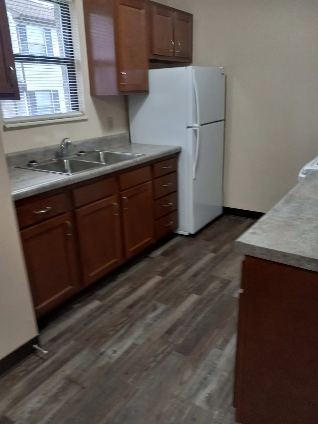 A kitchen with a white fridge and wooden cabinets.