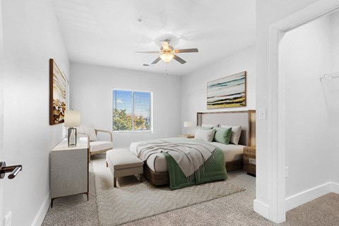 A bedroom with a large bed and a ceiling fan.