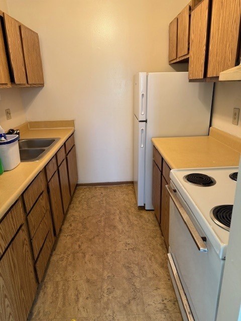 A kitchen with a white fridge and a white stove.