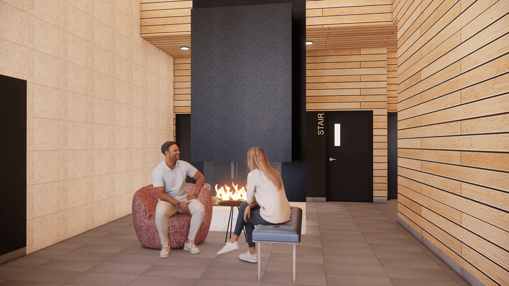 A man and a woman are sitting by a fireplace in a room with wooden walls.