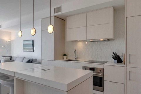 A modern kitchen with a white countertop and cabinets.