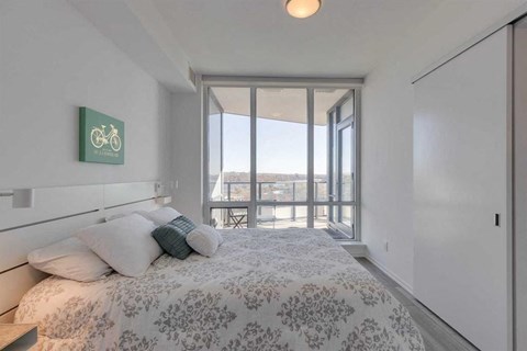 A bedroom with a large bed and a bicycle poster on the wall.