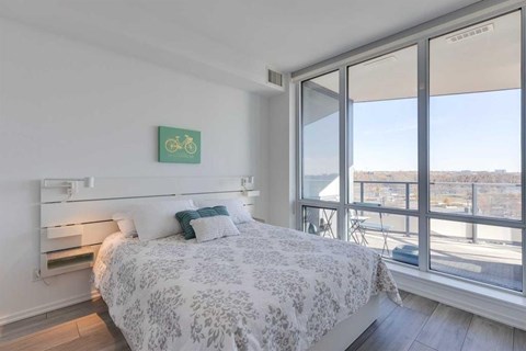 A bedroom with a large bed and a bicycle picture on the wall.