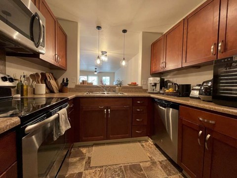 A kitchen with brown cabinets and a tiled floor.
