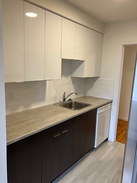 A kitchen with white cabinets and a sink.