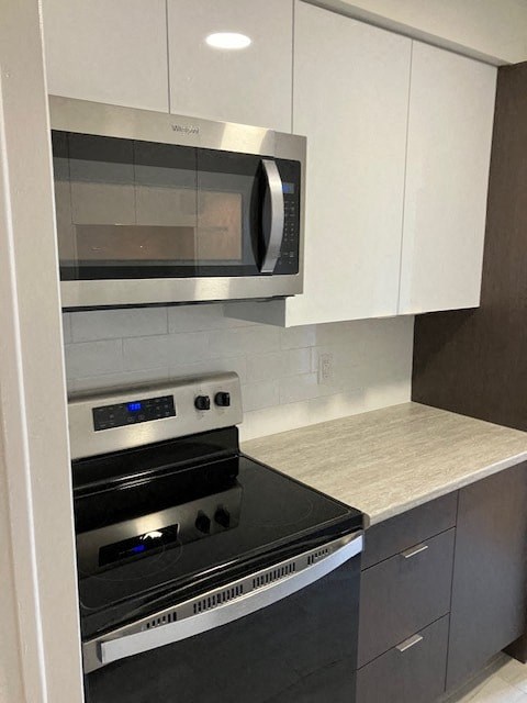 A modern kitchen with a stainless steel oven and microwave.