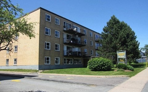 A large apartment building with a sign in front of it.