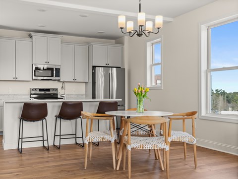 A kitchen with a table and chairs.