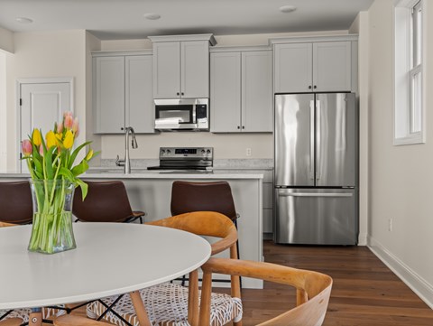 A kitchen with a refrigerator, stove, and microwave.