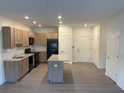 A kitchen with wooden cabinets and a black refrigerator.