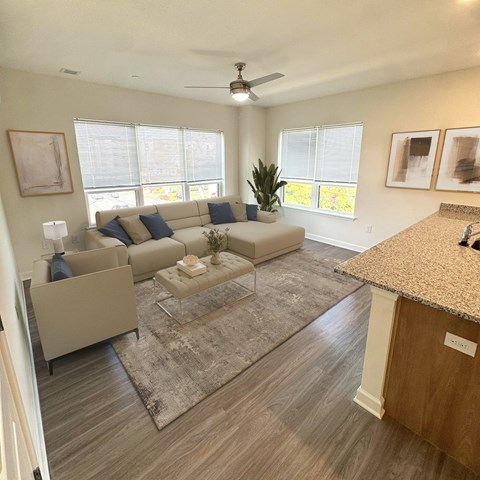 A living room with a couch, a coffee table, and a ceiling fan.
