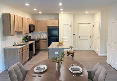 A modern kitchen with a dining table set for two.
