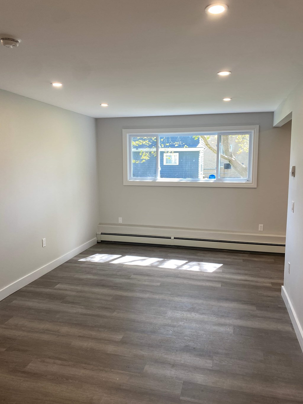 A room with a window and a radiator on the wall.