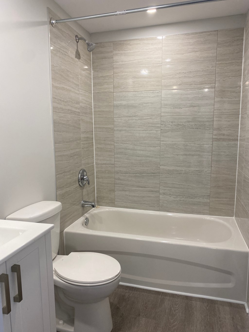 A white toilet sits next to a white bathtub in a bathroom.