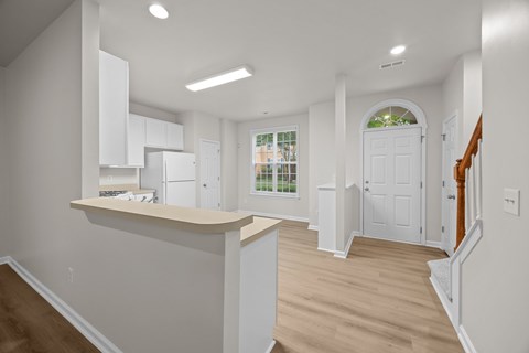 A kitchen with white cabinets and a window with a view of a cityscape.