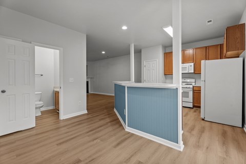 A kitchen with a white refrigerator and wooden cabinets.