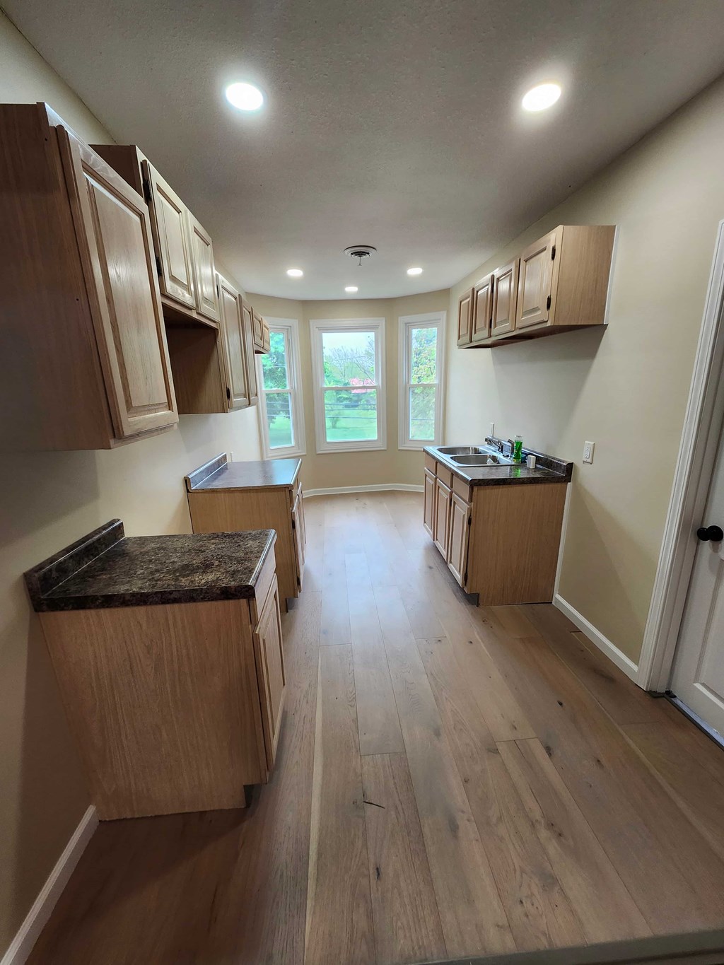A kitchen with wooden cabinets and a marble countertop.